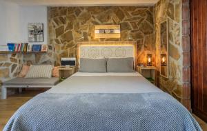 内尔哈内尔哈阳光一室公寓 的卧室配有一张石墙内的大床