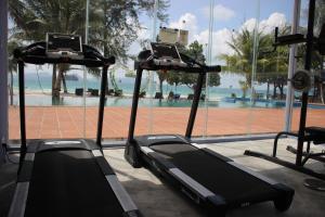 瓜隆岛SCARLET SAILS BUNGALOW的健身房在游泳池前设有两台跑步机