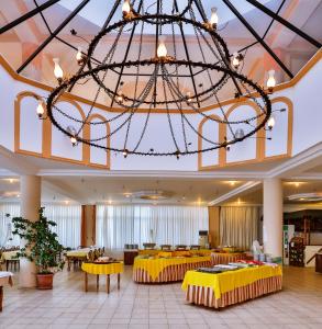 库古库俞Club Hotel Gultur的大型大堂设有黄色桌子和大吊灯