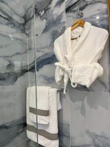 丹吉尔Centrico Tanger Idrissia 3的浴室设有玻璃墙上的白色毛巾