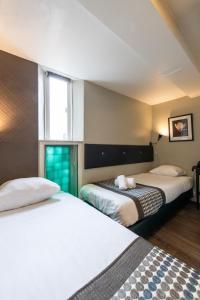 阿姆斯特丹阿科斯塔酒店的酒店客房设有两张床和窗户。