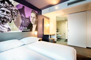 奥格斯堡B&B Hotel Augsburg-West的卧室配有一张壁挂式海报的床
