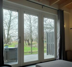 阿布考德Landelijk appartement in een mooi recreatiegebied的卧室内带2扇滑动玻璃门的房间