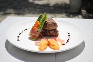 瓜隆岛SCARLET SAILS BUNGALOW的桌上一盘带肉和蔬菜的食物