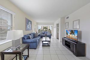 马可岛海滩俱乐部417度假屋的客厅配有蓝色的沙发和电视