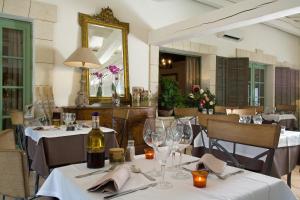 艾格-莫尔特玛斯德塞博斯酒店的餐厅设有桌子、酒杯和镜子