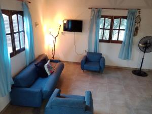 拉班达La Casita的客厅配有蓝色的沙发和两把椅子