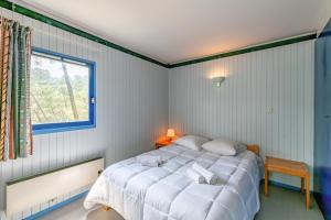 卡尔康Résidence les Cavales的卧室配有白色的床和窗户。