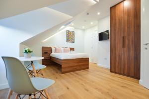 伦敦West Hampstead Serviced Apartments by Concept Apartments的卧室配有一张床和一张桌子及椅子