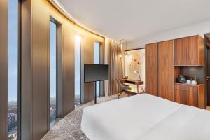 慕尼黑HYPERION Hotel München的酒店客房设有一张床、一张书桌和窗户。
