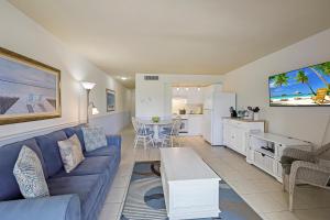 马可岛Beach Club 216的一间带蓝色沙发的客厅和一间厨房