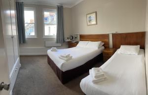 滕比克拉伦斯酒店的酒店客房设有两张床和窗户。