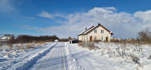 克维曾Zimna Apartments的田野上雪覆盖的路上的房子