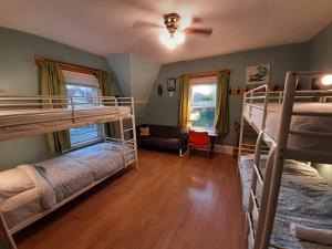 夏洛特顿HI Charlottetown Backpacker's Inn的客房设有两张双层床和一张沙发。
