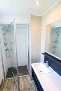 AzurCAMPING AZU'RIVAGE的带淋浴、盥洗盆和镜子的浴室