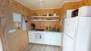 海德利桑德Gotuhus - Sea View Apartment的厨房配有白色冰箱和木墙