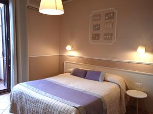 圣安蒂奥科意大利餐厅摩登酒店的卧室配有一张床,墙上有两盏灯