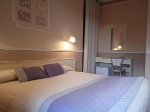 圣安蒂奥科意大利餐厅摩登酒店的一间卧室配有一张大床和一张书桌