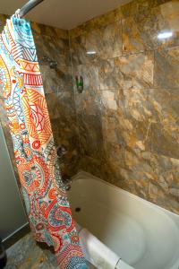 费城Philly Inn & Suites的带浴缸的浴室和瓷砖墙