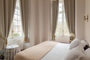 埃尔芒翁维尔杜阿蒙农维拉城堡酒店的卧室配有白色床和2扇窗户