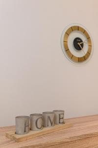 布拉索夫JAD - Luxury Studio - Soarelui 10的木架上的钟和三杯,上面写着妈妈