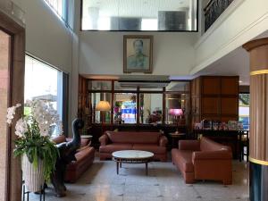 曼谷珍宝多酒店 的大厅,在大楼里配有沙发和桌子