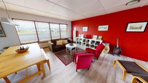 海德利桑德Brenna: Cliffside Apartment的客厅设有红色的墙壁和桌椅