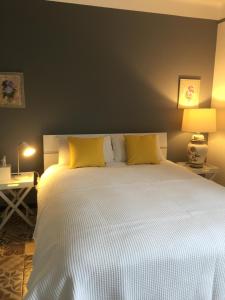 MontazelsChez Montiz的卧室配有一张带黄色枕头的大型白色床。