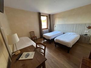 梅藏塔勒奶客栈的酒店客房设有两张床、一张桌子和一张书桌。