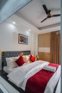 古尔冈The Lodgers 1 BHK Serviced Apartment Golf Course Road Gurgaon的一间卧室配有一张带红色枕头的大床