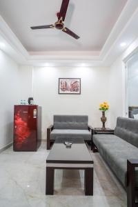 古尔冈The Lodgers 1 BHK Serviced Apartment Golf Course Road Gurgaon的客厅配有两张沙发和一张咖啡桌