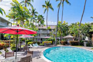 科纳Kona Islander Inn 147 Tropical Oasis的一个带椅子和遮阳伞的度假村游泳池