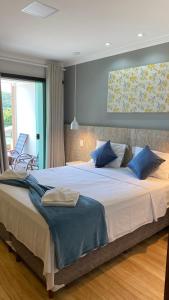 卡皮托利乌Pousada Vale do Chapéu的一间卧室配有一张带蓝色枕头的大床