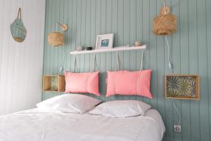 拉罗谢尔La Mariennée的一间卧室配有带粉色和白色枕头的床