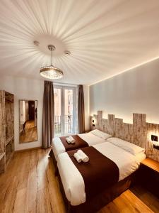 马德里Hostal Anton Martin的一间卧室配有一张大床和一个吊灯。