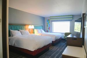 利德Hampton Inn Lead的酒店客房设有两张床和窗户。