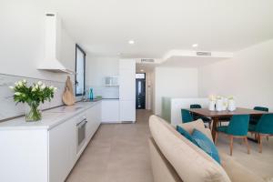 阿德耶200m NEW A Villa with private, heated pool and amazing ocean view的厨房以及带桌椅的起居室。