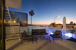 阿德耶200m NEW A Villa with private, heated pool and amazing ocean view的阳台的天井配有桌椅