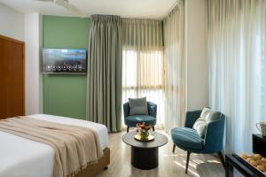 特拉维夫马克西姆3星级高级设计酒店的酒店客房,配有一张床和两把椅子