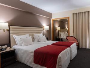 维拉·雷阿尔米拉科格酒店的酒店客房设有一张带红色毯子的大床