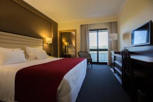 维拉·雷阿尔米拉科格酒店的酒店客房配有一张床、一张书桌和一台电视。