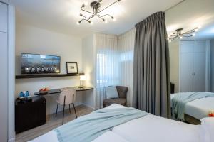 特拉维夫马克西姆3星级高级设计酒店的酒店客房设有一张床、一张书桌和一台电视机。