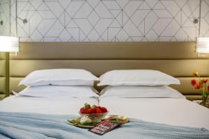 特拉维夫马克西姆3星级高级设计酒店的一张带一碗水果和一盘草莓的床