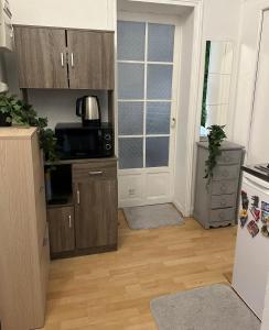 巴黎Nice Private Room in center的带木制橱柜的厨房和带冰箱的厨房。