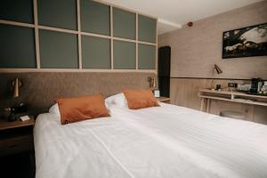伊皮Witte Berken Natuurhotel的卧室配有一张带两个橙色枕头的大白色床