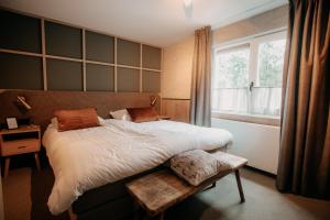 伊皮Witte Berken Natuurhotel的一间卧室设有一张大床和一个窗户。