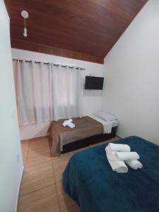 圣佩德罗塞拉Suites Estrela的小房间设有两张床和窗户