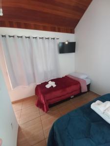 圣佩德罗塞拉Suites Estrela的一间设有两张床和红色毯子的房间