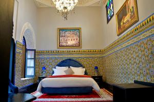 拉巴特Dar Chrifa的一间卧室配有一张床和一个吊灯