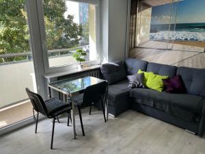 格但斯克Apartament Baltic Sea的客厅配有蓝色的沙发和玻璃桌